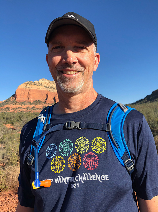 Man Standing In Front Of Red Rock